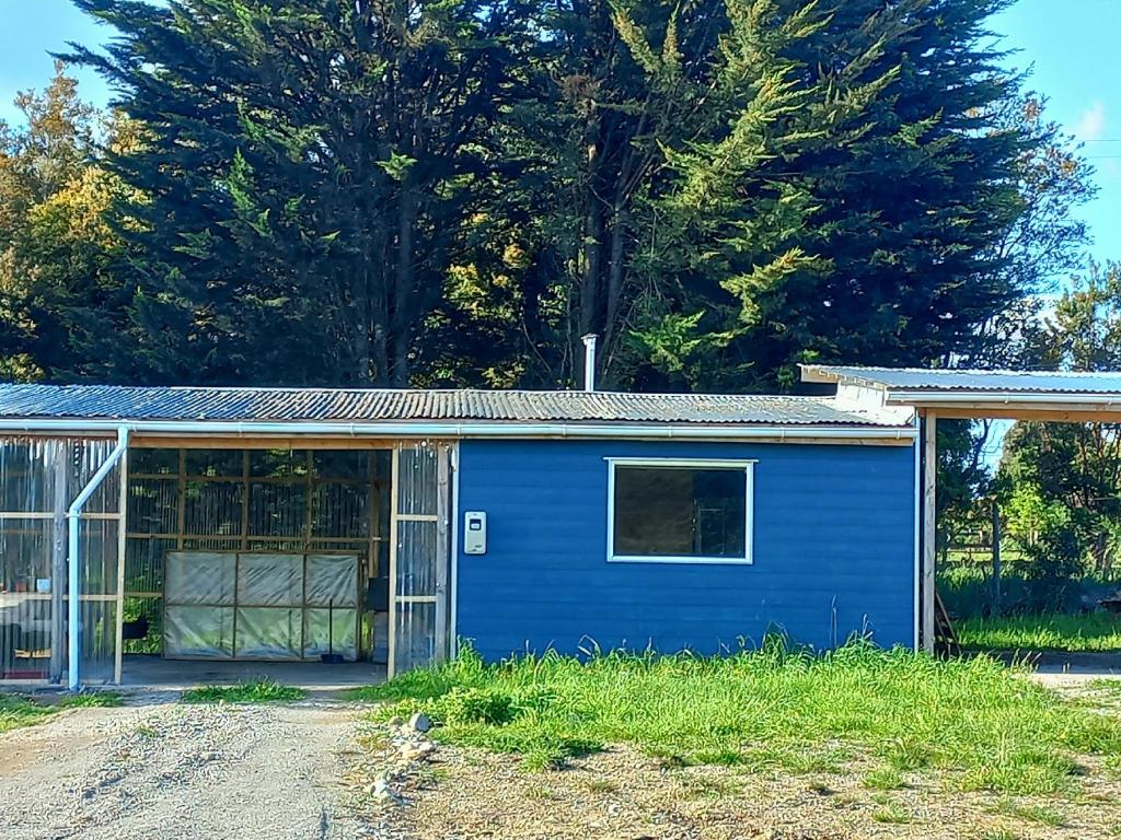 un cobertizo azul con una ventana en un patio en Casa Leon, en Puerto Varas