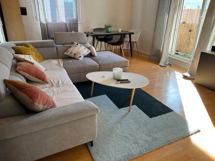 uma sala de estar com um sofá e uma mesa em Appartement avec un séjour balcon très lumineux em Orléans