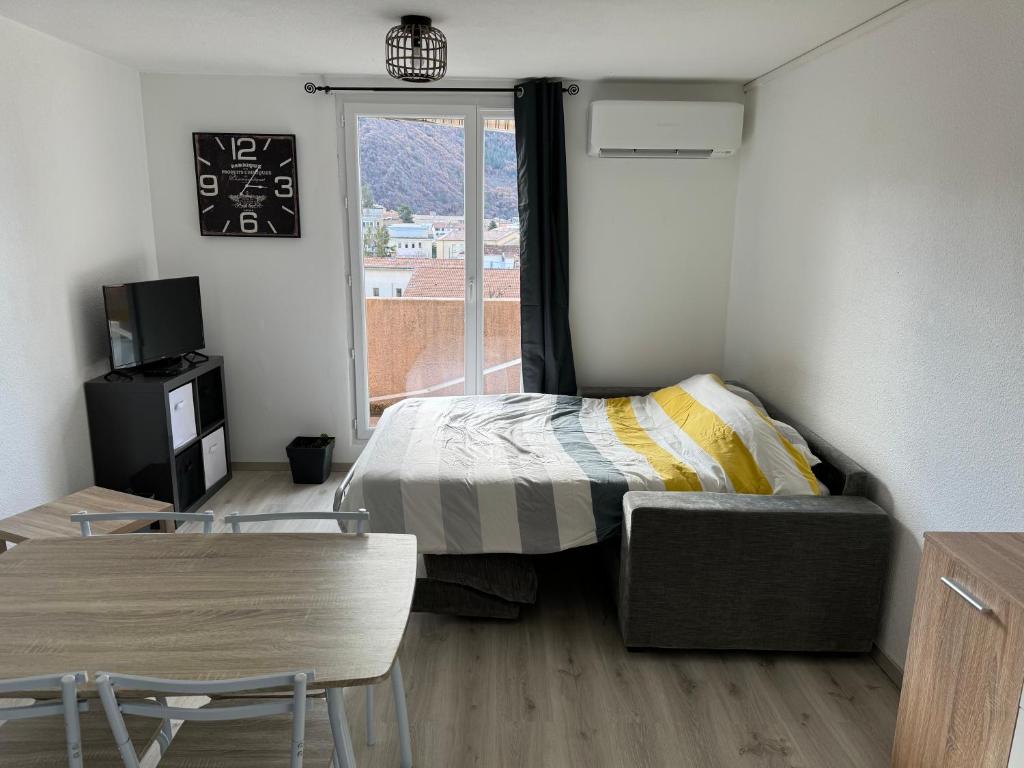 a small bedroom with a bed and a window at Studio avec terrasse vue sur cousson in Digne-les-Bains
