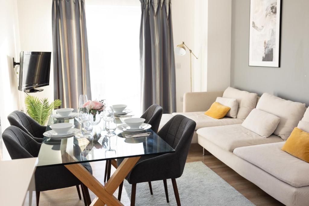 uma sala de estar com uma mesa de vidro e cadeiras em Modern, comfy 2 bedroom flat in Hatfield town centre em Hatfield