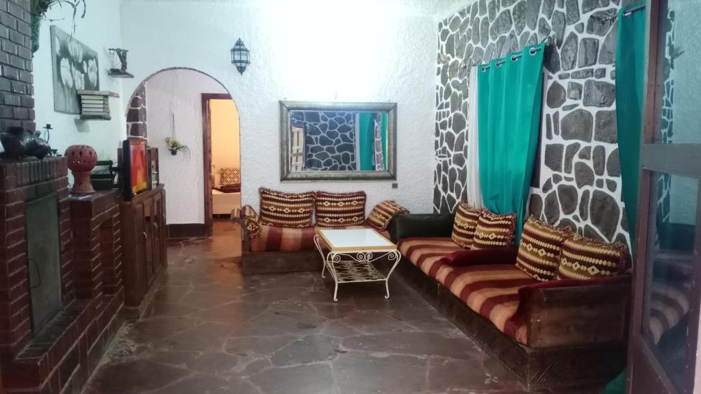 uma sala de estar com um sofá e uma mesa em the river house em Aghbalou