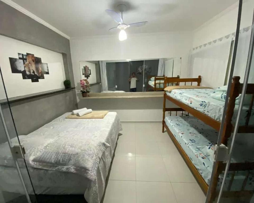 Hospedagens Alex في باراتي: غرفة نوم مع سريرين بطابقين ومرآة