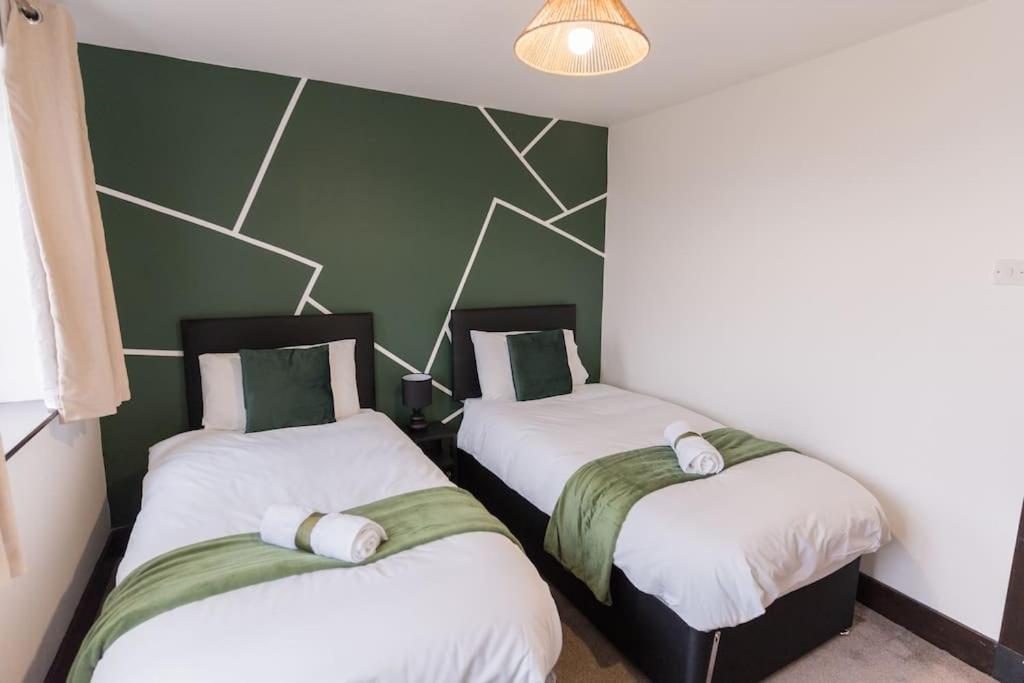 Apartment in Warwick - Families - Business - Contractors في وارويك: سريرين في غرفة بجدران خضراء وبيضاء