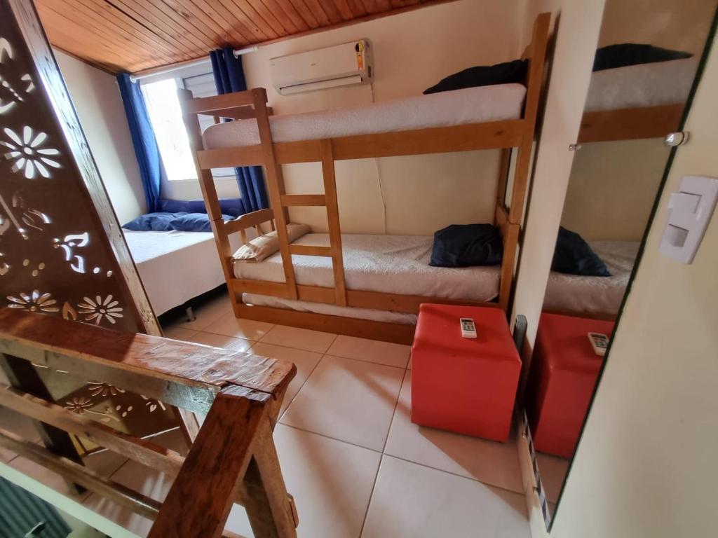 a room with two bunk beds and a red suitcase at Ohana's Flat Maresias in São Sebastião