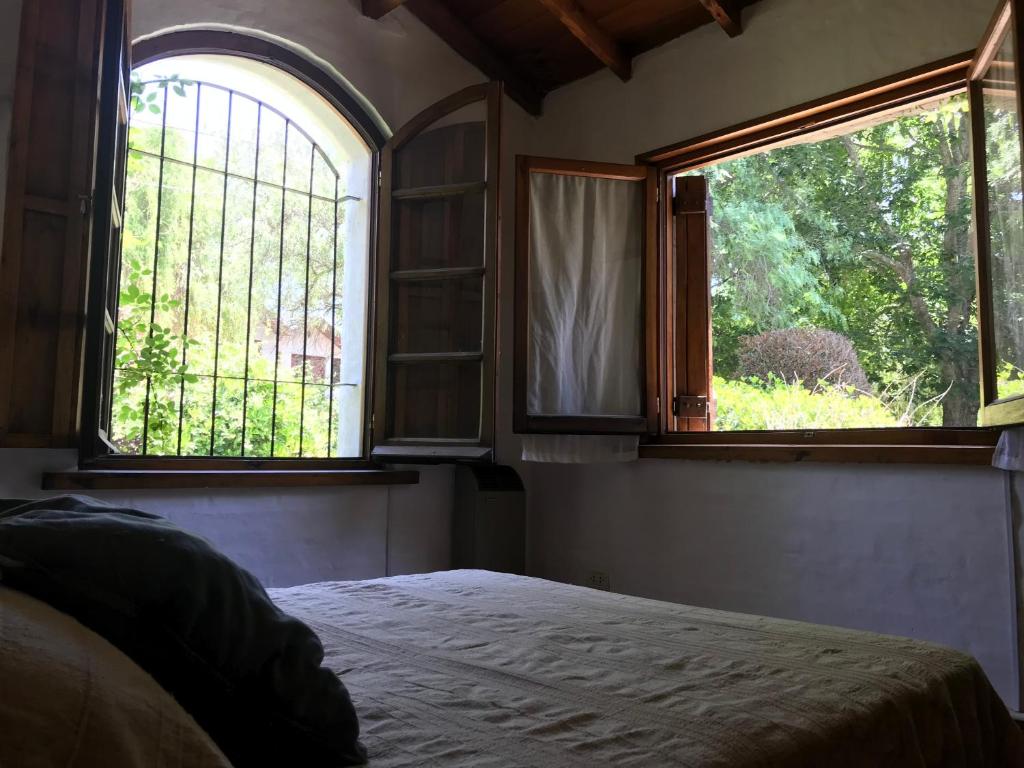 um quarto com duas janelas e uma cama. em Casa La Florida em Mar del Plata
