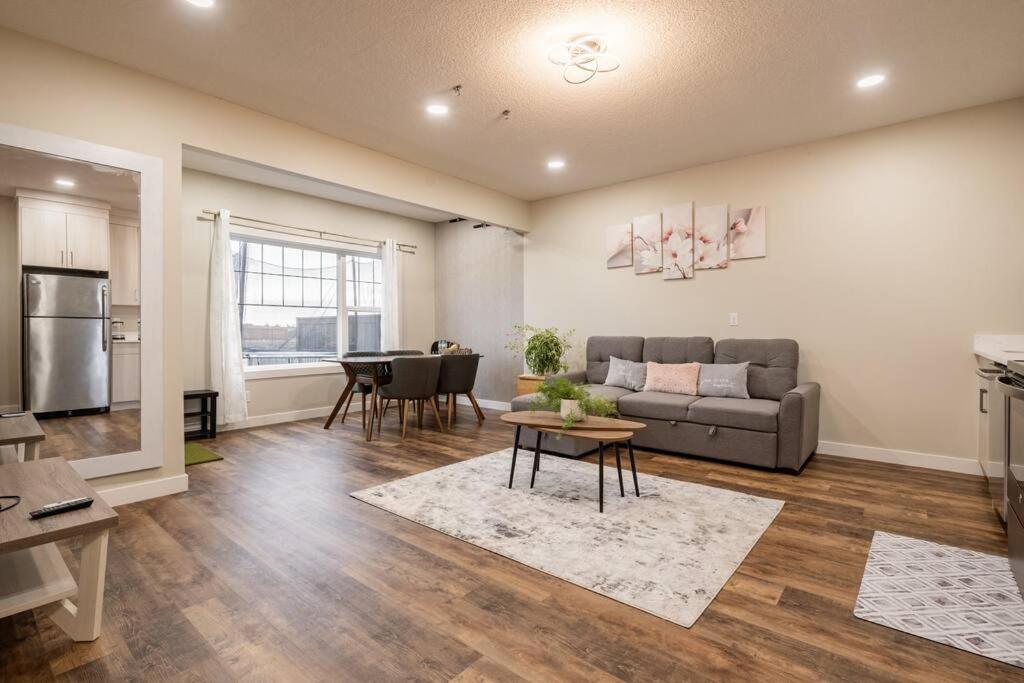 ein Wohnzimmer mit einem Sofa und einem Tisch in der Unterkunft New&Stylish&Cozy Suit near Spruce Meadows Sleeps 6- Backyard-EV in Calgary