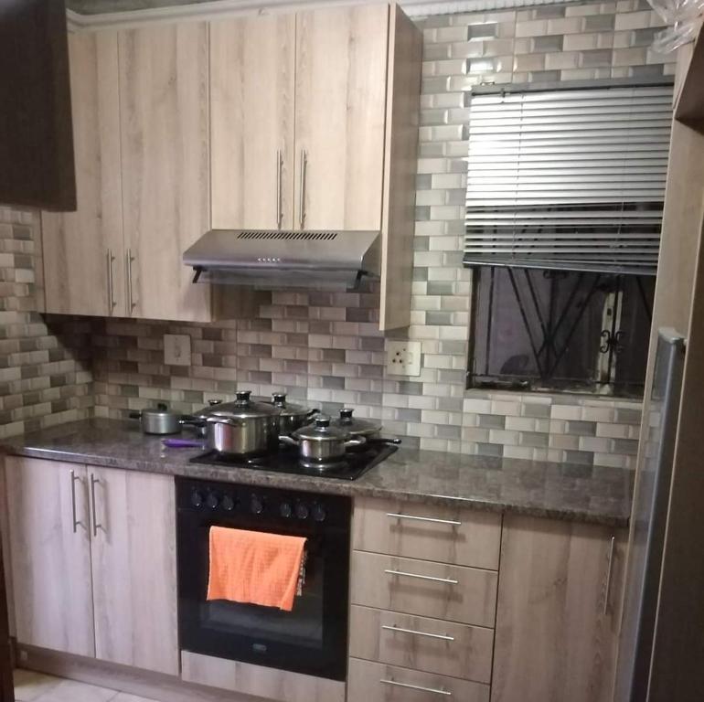una cocina con fogones con ollas y sartenes. en GLOBAL PRIDE en Soweto
