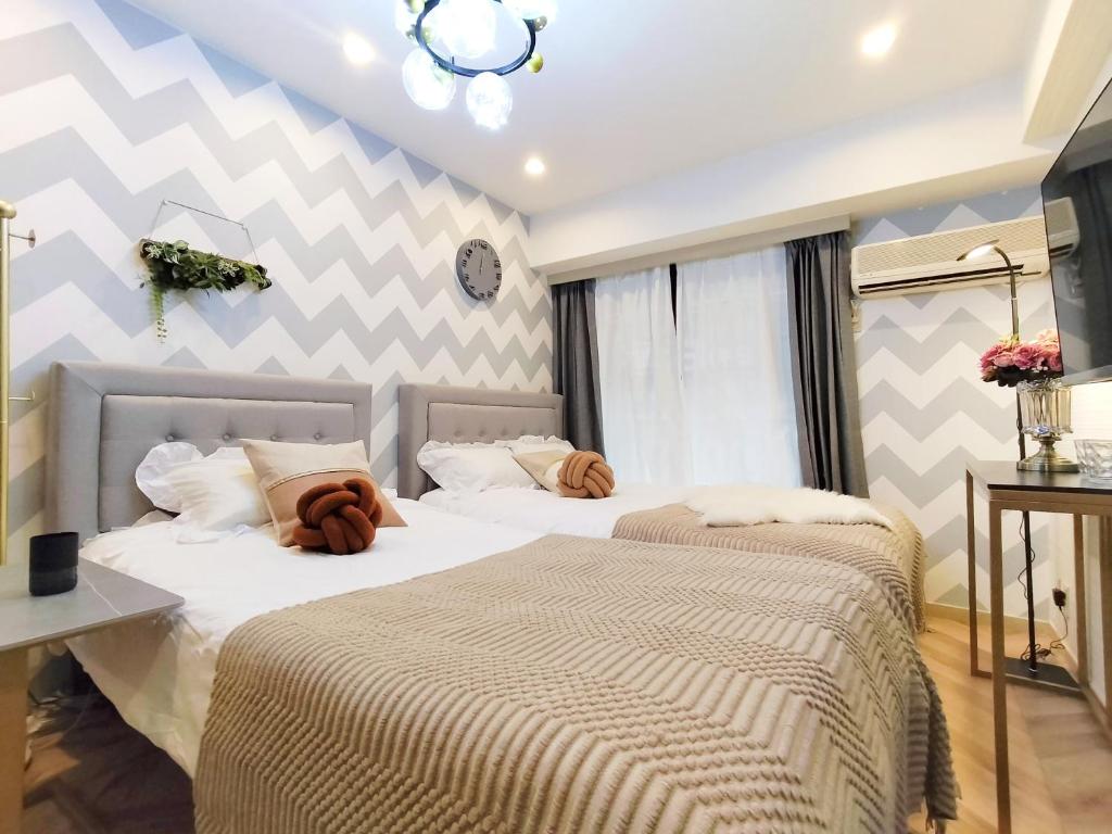 Dos camas una al lado de la otra en un dormitorio. en G23新宿最中心 東新宿站5分-Shinjuku center 5 mins to Station, Max 3P 新宿 涉谷 表参道 池袋 上野 代代木 银座 原宿, en Tokio