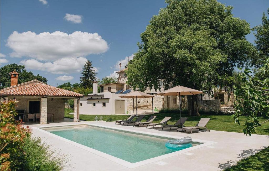 - une piscine avec des chaises et des parasols à côté d'une maison dans l'établissement Casa Amalia, à Višnjan
