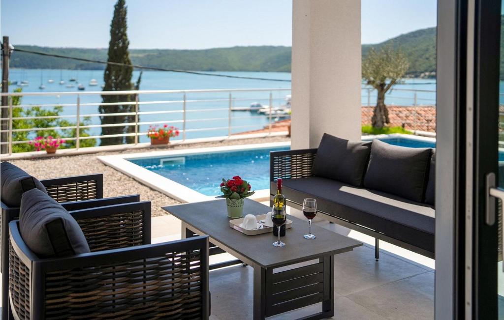 eine Terrasse mit einem Tisch, Stühlen und einem Pool in der Unterkunft Villa Cincin in Raša