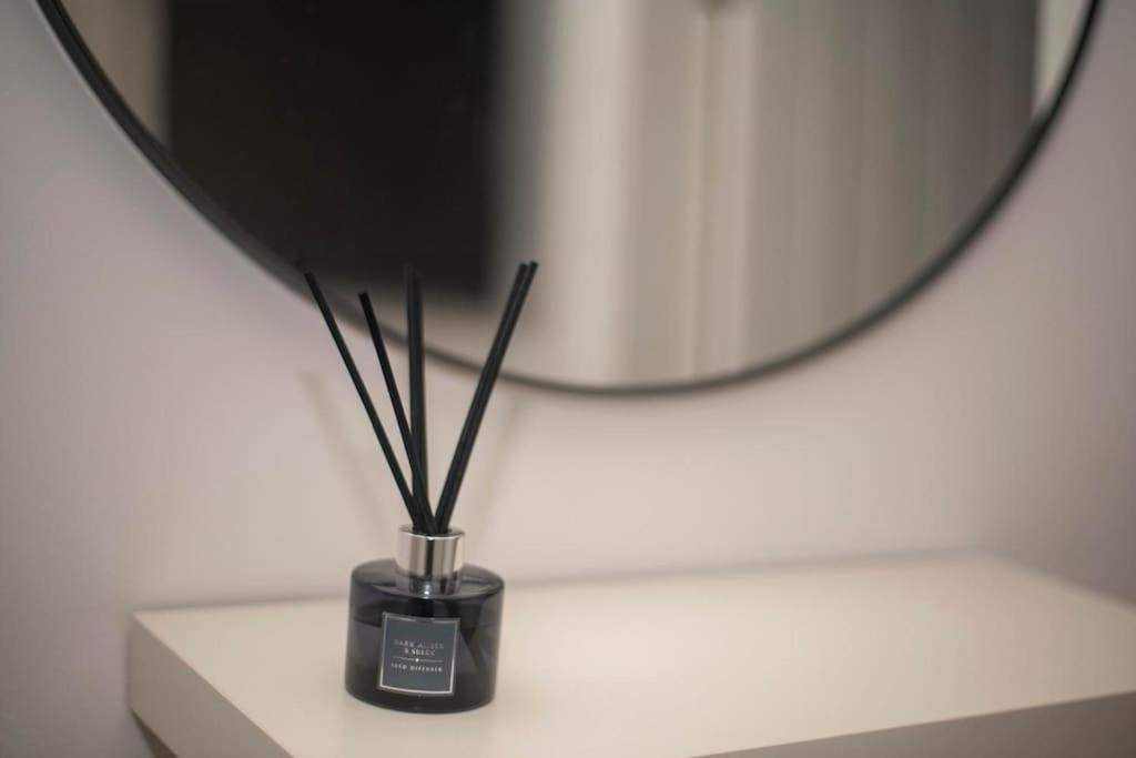 a vase with sticks on a table in front of a mirror at Luxury two bedroom apartment in Wilpshire