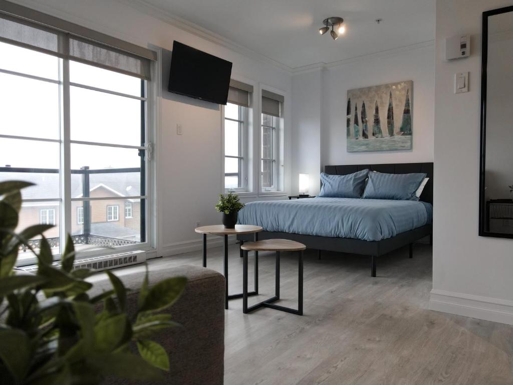 een slaapkamer met een bed en een groot raam bij Modern Loft Chute-Montmorency in Boischâtel