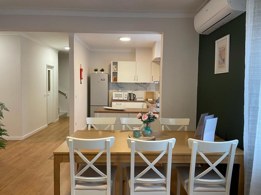 a dining room and kitchen with a table and chairs at Villa Dona Rosa - Viana do Castelo in Viana do Castelo