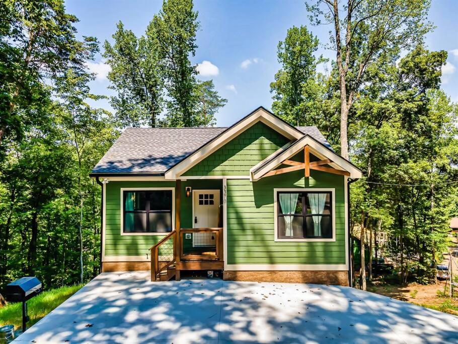 a green tiny house with a driveway at Three Cubs Den - Minutes to PF Strip, Hot Tub, Arcade Games, Bunks, View in Pigeon Forge