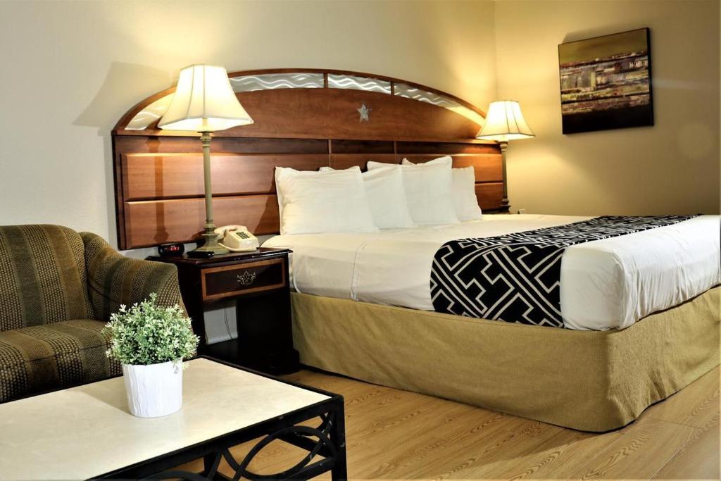 キシミーにあるHotel Monte Carloのベッドとソファ付きのホテルルーム
