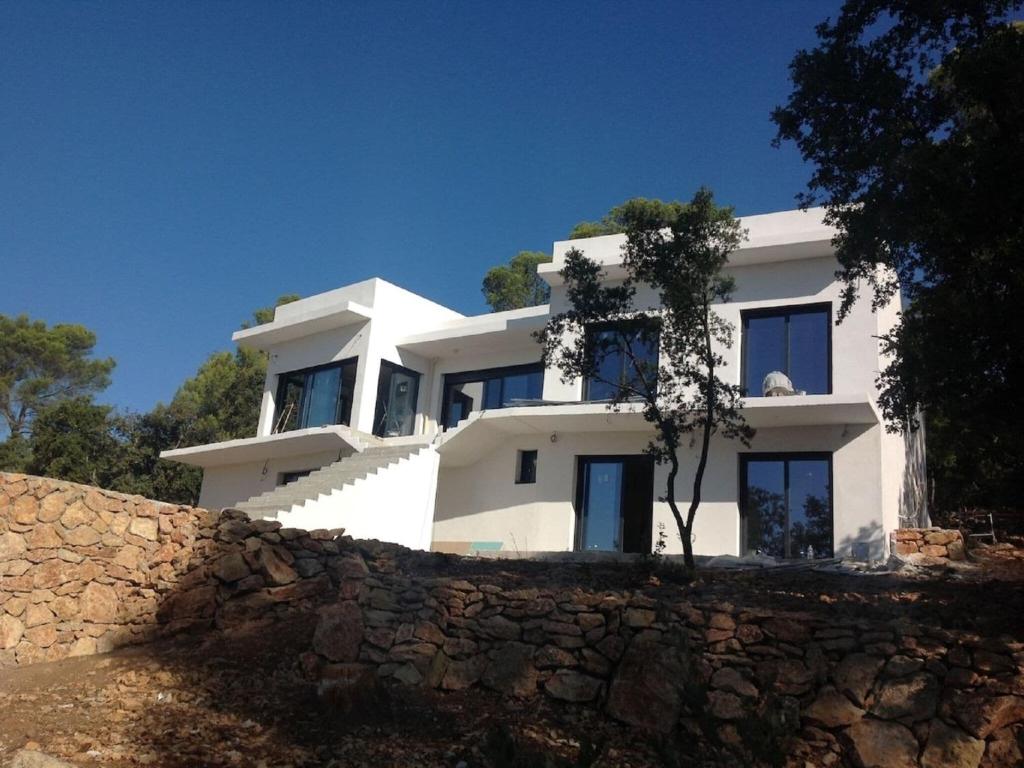 uma casa branca no topo de uma parede de pedra em Architectural villa with swimming pool em Lorgues