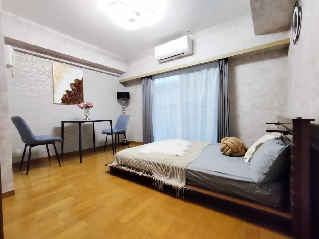 una camera da letto con un letto, un tavolo e delle sedie di B25新宿最中心 新宿站10分-Shinjuku center 10 mins to Station, Max 4 直达新宿 涉谷 表参道 池袋 上野 代代木 银座 原宿 a Tokyo