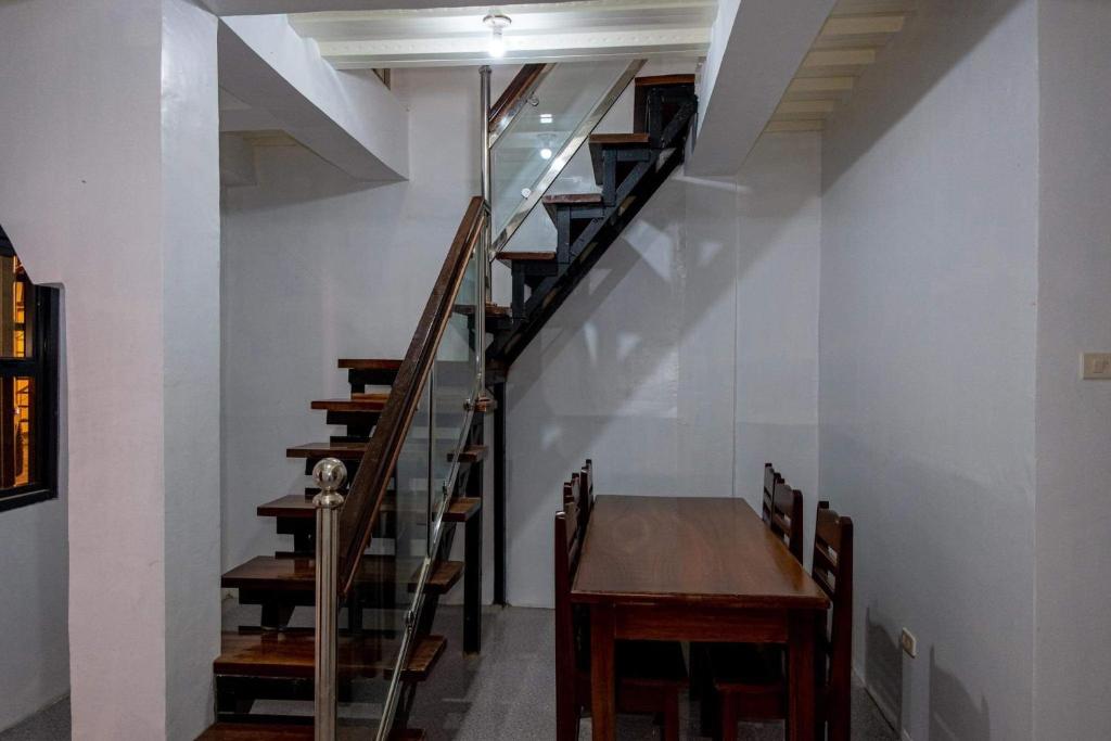 a staircase in a room with a table and a wooden table at robiants apartment in Kinatilan