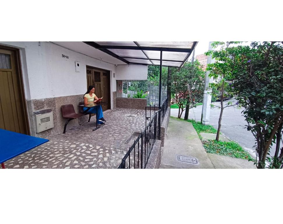 una mujer sentada en una silla bajo un paraguas en Hermosa vivienda central en el mejor lugar de Medellín en Envigado