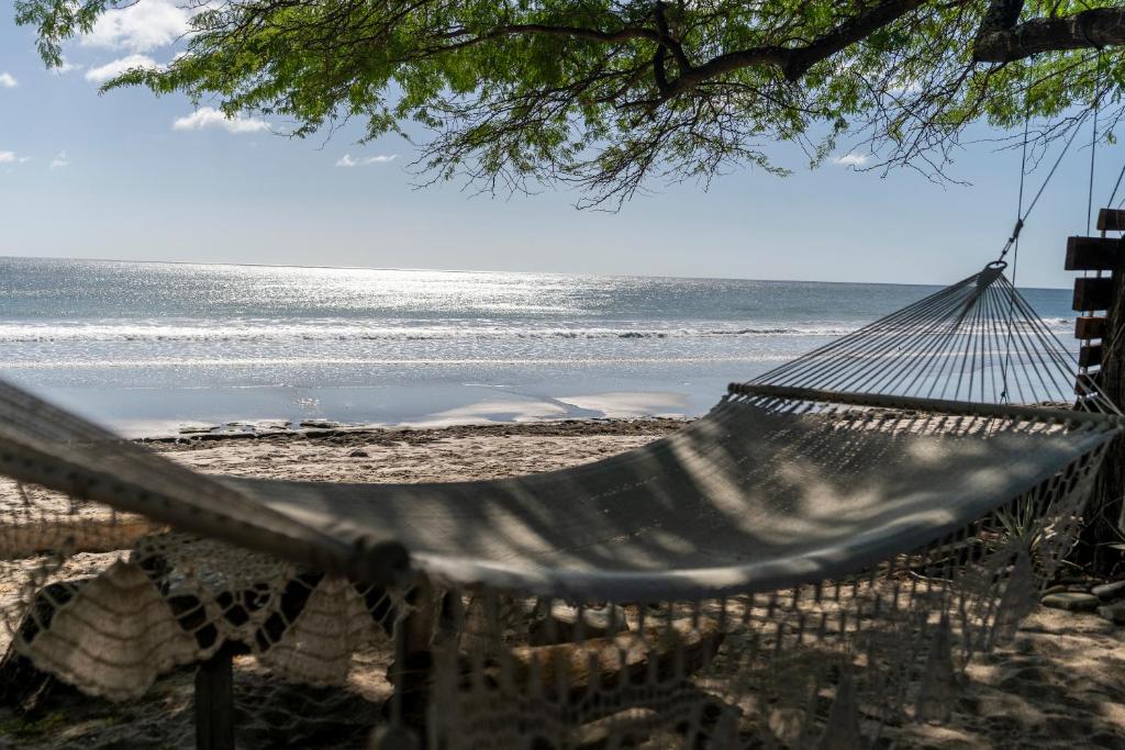 a hammock on a beach with the ocean at Popoyo Republic in Popoyo