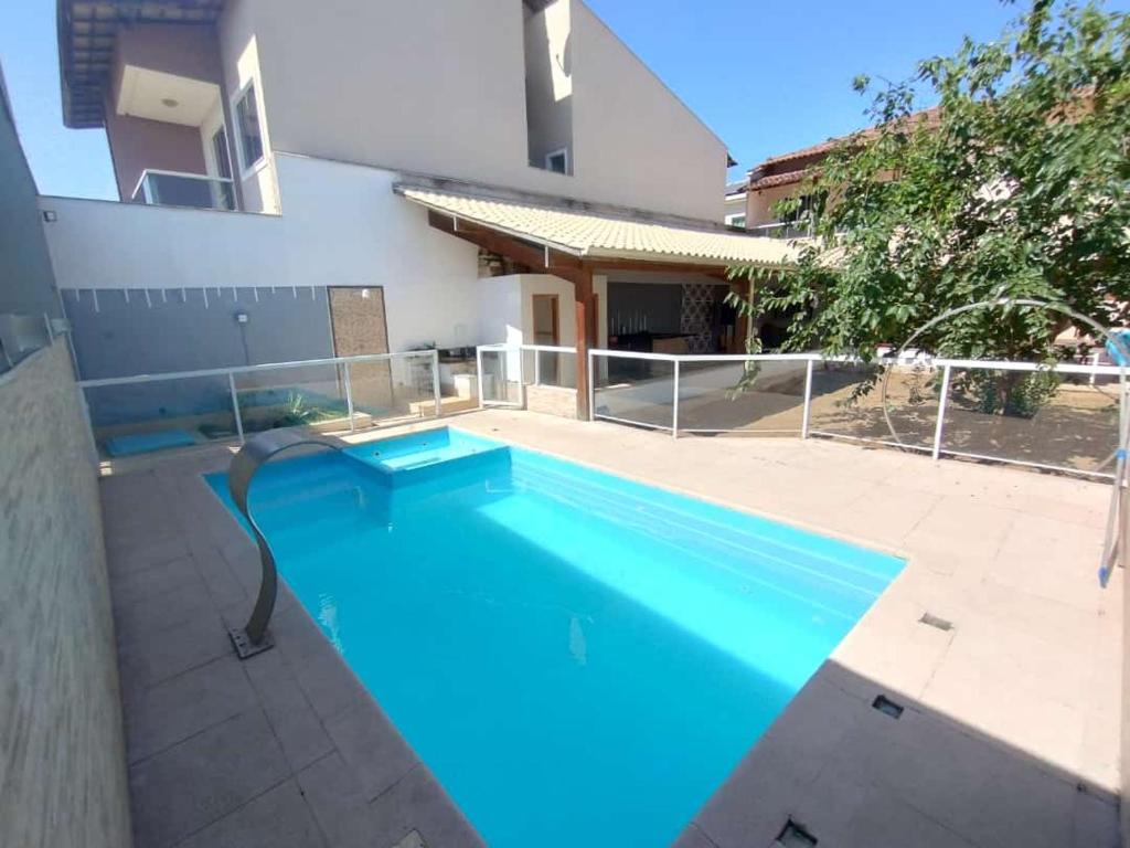 a large blue swimming pool in front of a house at Casa e Lazer em Colina de Laranjeiras in Serra