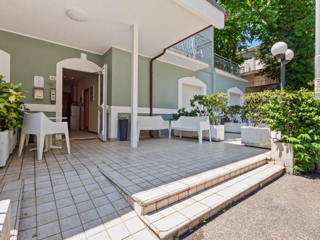 a patio with white chairs and a table at Modern Apartment in Rimini with Balcony in Rimini