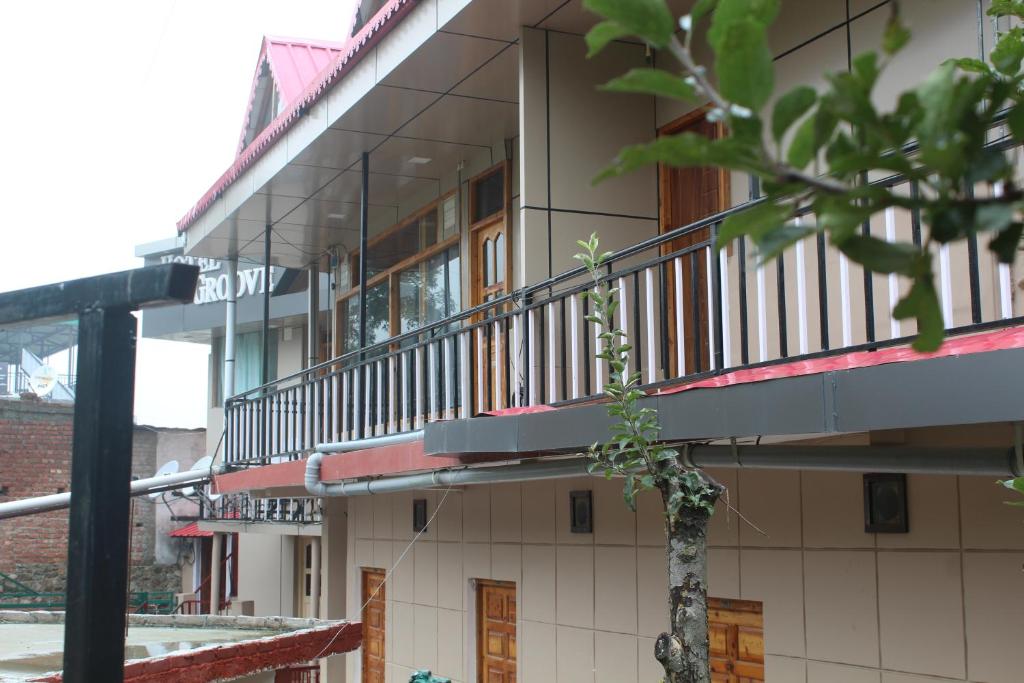 ein Gebäude mit einem Balkon auf der Seite in der Unterkunft THE GROOVE GARDEN DHANOLTi in Dhanaulti
