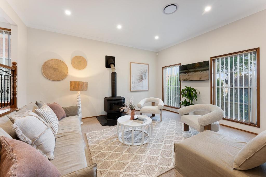 a living room with a couch and a table at Shell Cove Coastal Haven in Shellharbour