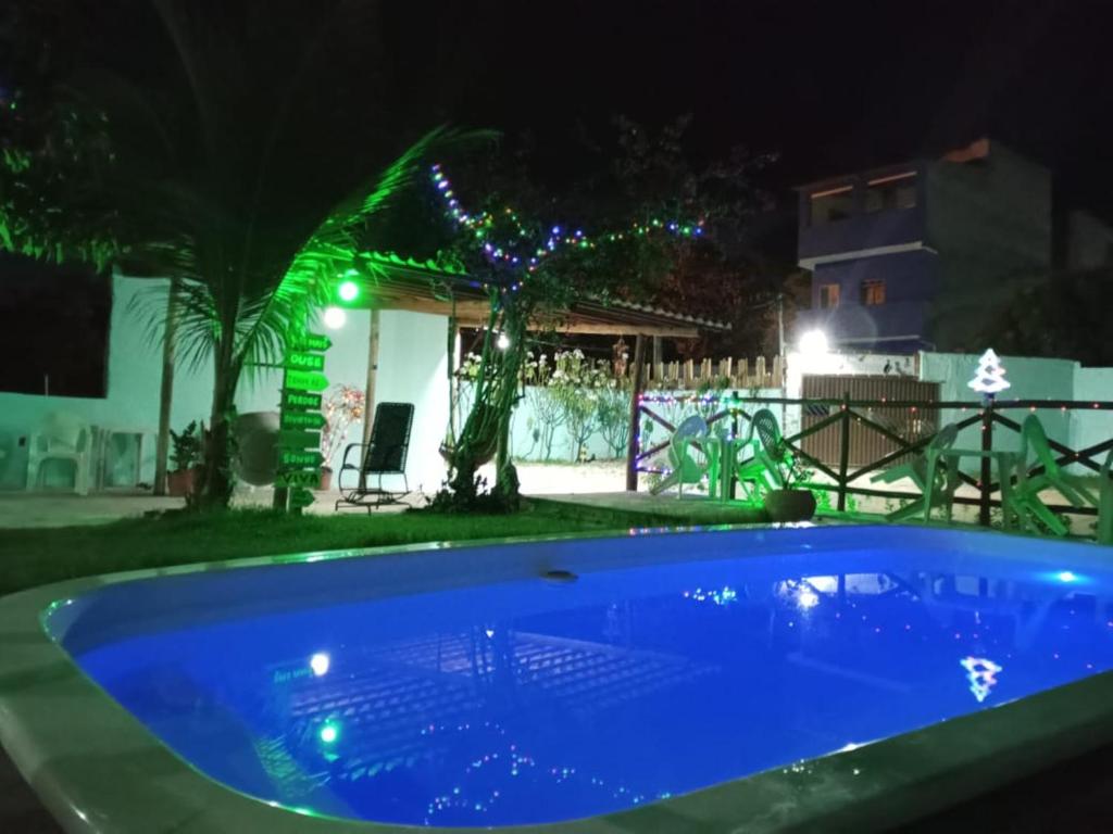 una piscina azul en un patio por la noche en Pousada Sol de Imbassai en Imbassai