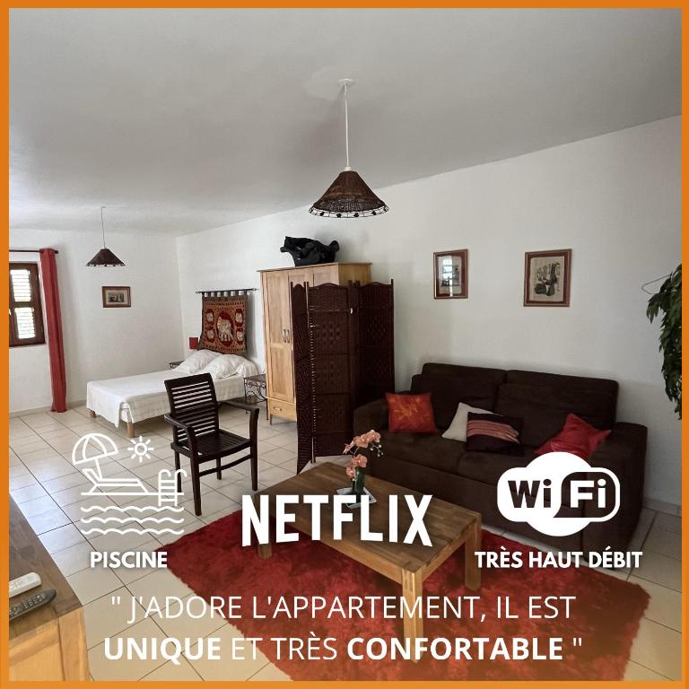 a living room with a couch and a table at RUBIS-Villa le colibri in Dubédou