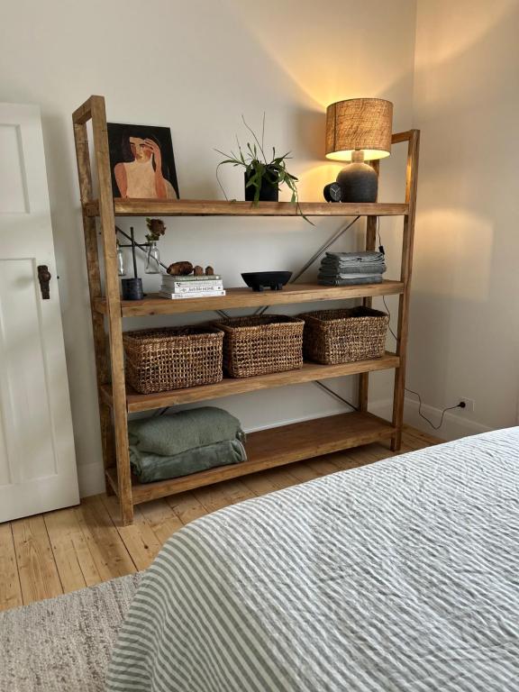 a room with a shelf with baskets and a bed at Cozy 2 bedroom cottage - Newly renovated, perfect location for best of Ballarat in Ballarat