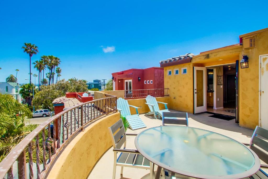 a patio with a glass table and chairs on a balcony at Rooftop Paradise w Private Patio, Garage & AC in San Diego