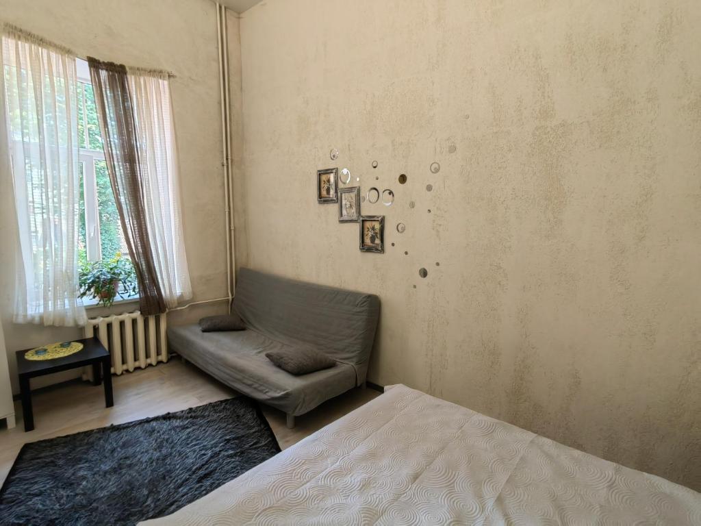 ein Wohnzimmer mit einem Sofa und einem Stuhl in der Unterkunft Apartment in city center in Daugavpils