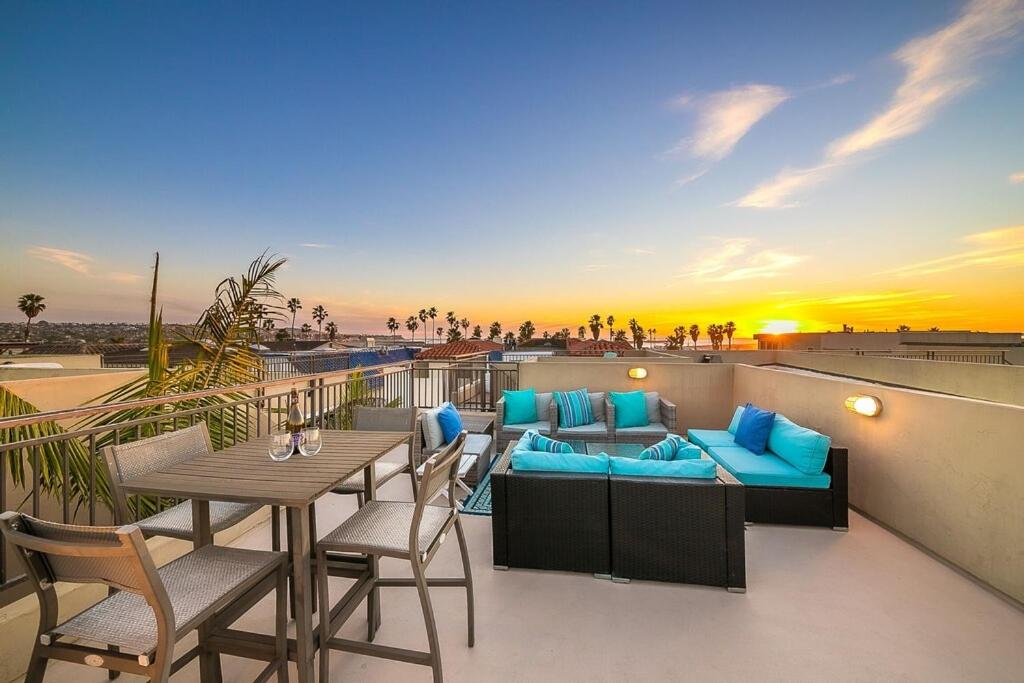 uma varanda com um sofá, uma mesa e cadeiras em Stunning South Mission Home with Private Rooftop & Ocean Views! em San Diego