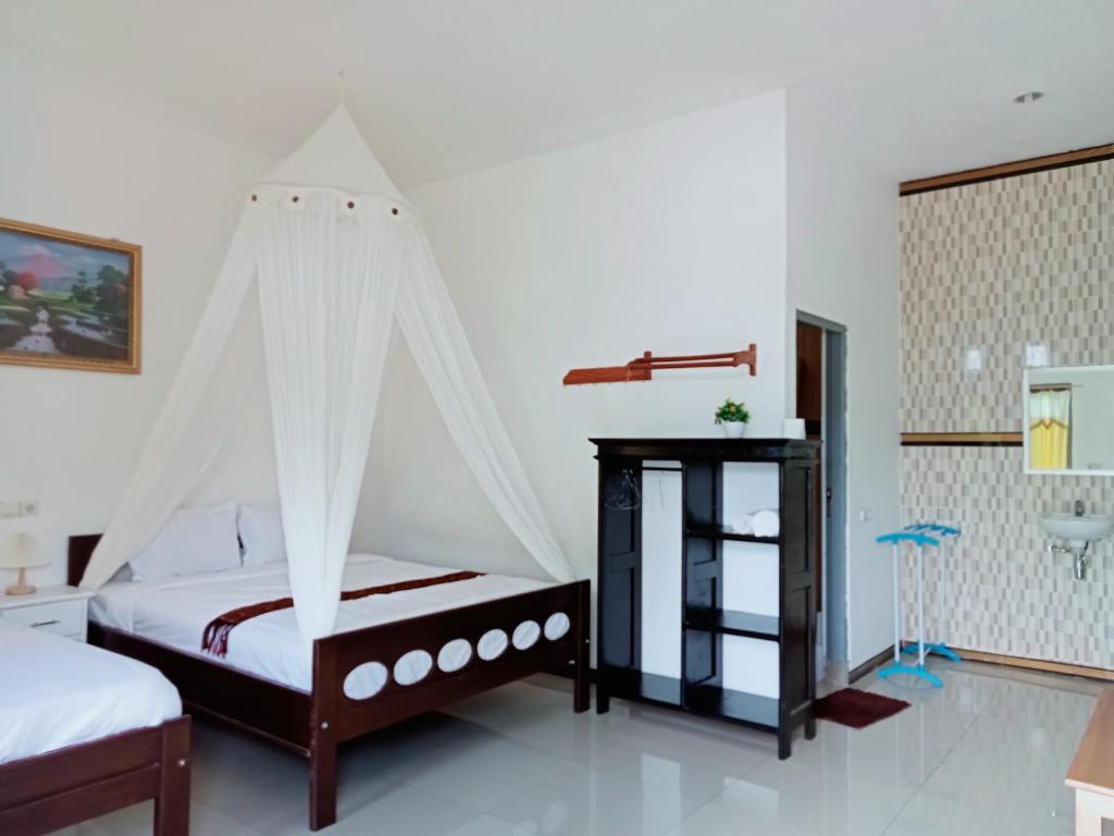 a bedroom with a bed with a mosquito net at Mahakali in Kelimutu