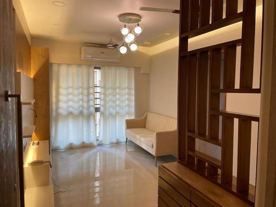 - un salon avec un canapé et une fenêtre dans l'établissement 1-BHK:Where Comfort Meets luxury, à Mumbai
