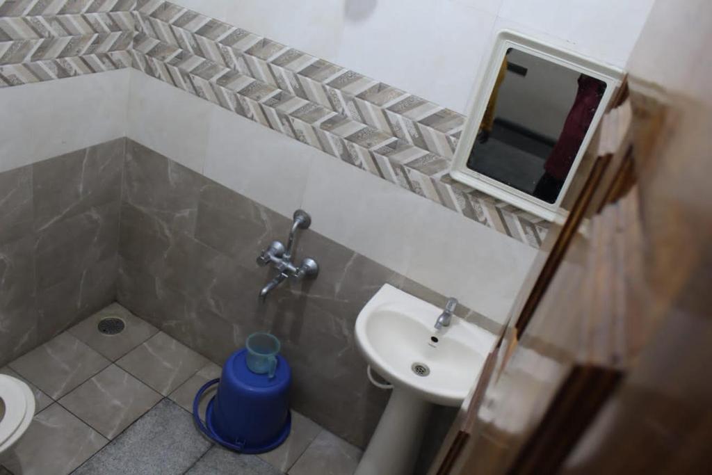 a small bathroom with a sink and a mirror at Regency apartment in Mysore