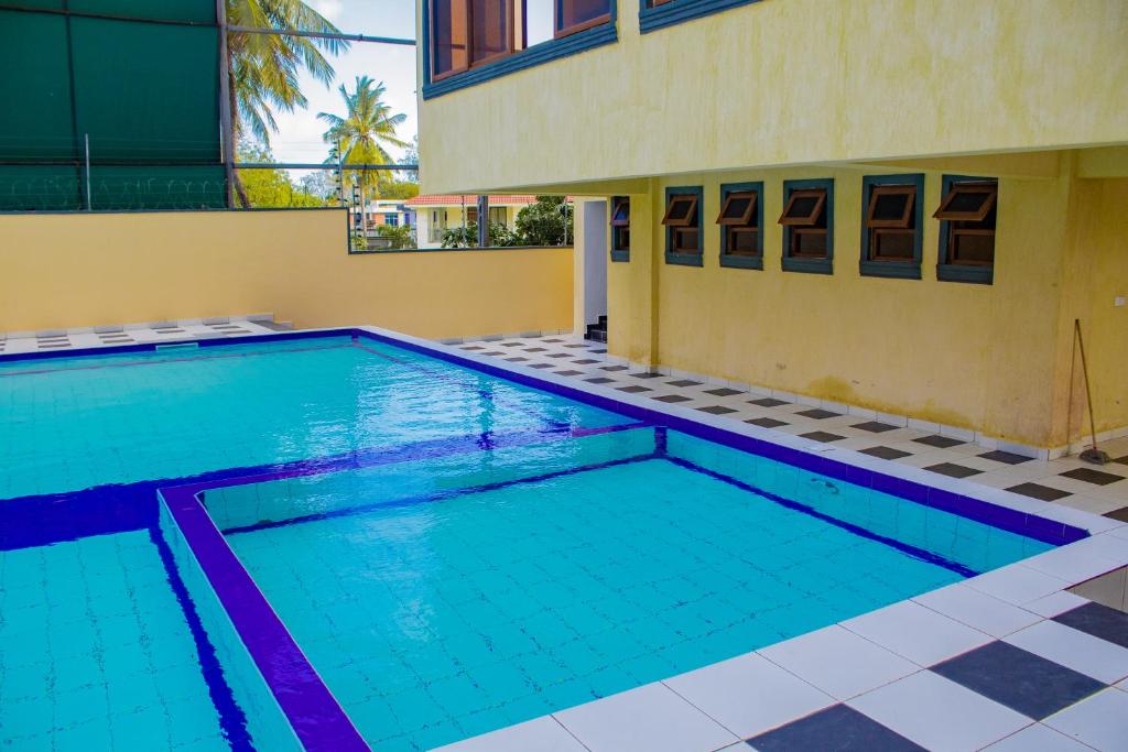 a swimming pool in front of a building at Destiny homes in Mombasa
