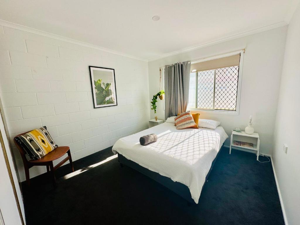 a bedroom with a bed and a chair and a window at Island Villas - Lady Elliott - Unit 2 in Bundaberg