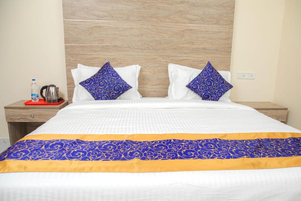 a bedroom with a large bed with blue and white pillows at RedFox Hotel-T.Nagar in Chennai