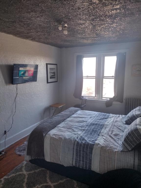 1 dormitorio con 1 cama y TV en la pared en Clearviewpeace, en Paterson