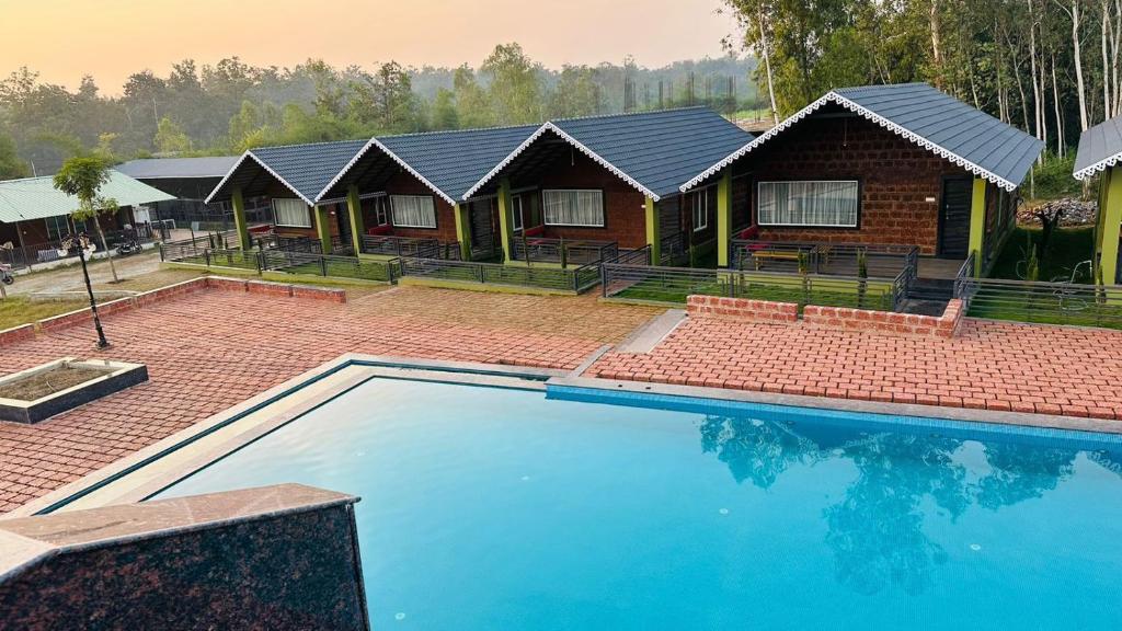 una casa con piscina delante de una casa en Dandeli Wild Jungle Resort, en Dandeli