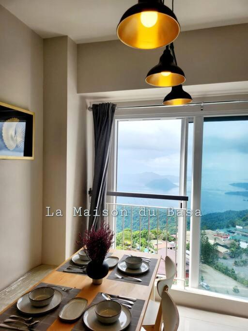 a dining room table with a view of a window at SMDC Wind: T2 La Maison du Basa in Tagaytay