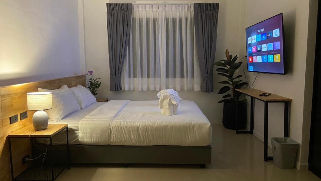 a bedroom with a bed and a tv in a room at B House Phuket @Chalong in Chalong 