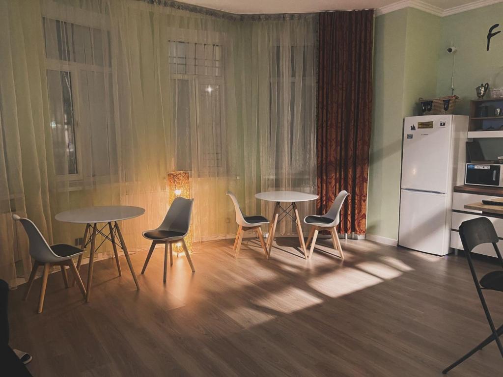 a kitchen with two tables and chairs and a refrigerator at Friends Hostel in Astana