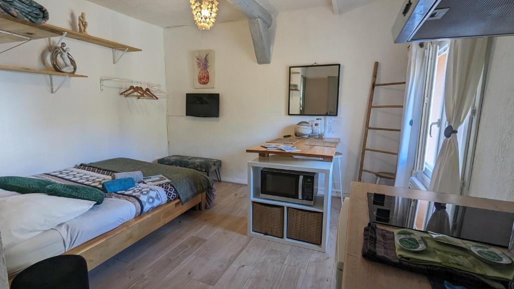 a small room with a bed and a television at STUDIO avec PARKING TOUT A PIED et CALME in Bandol