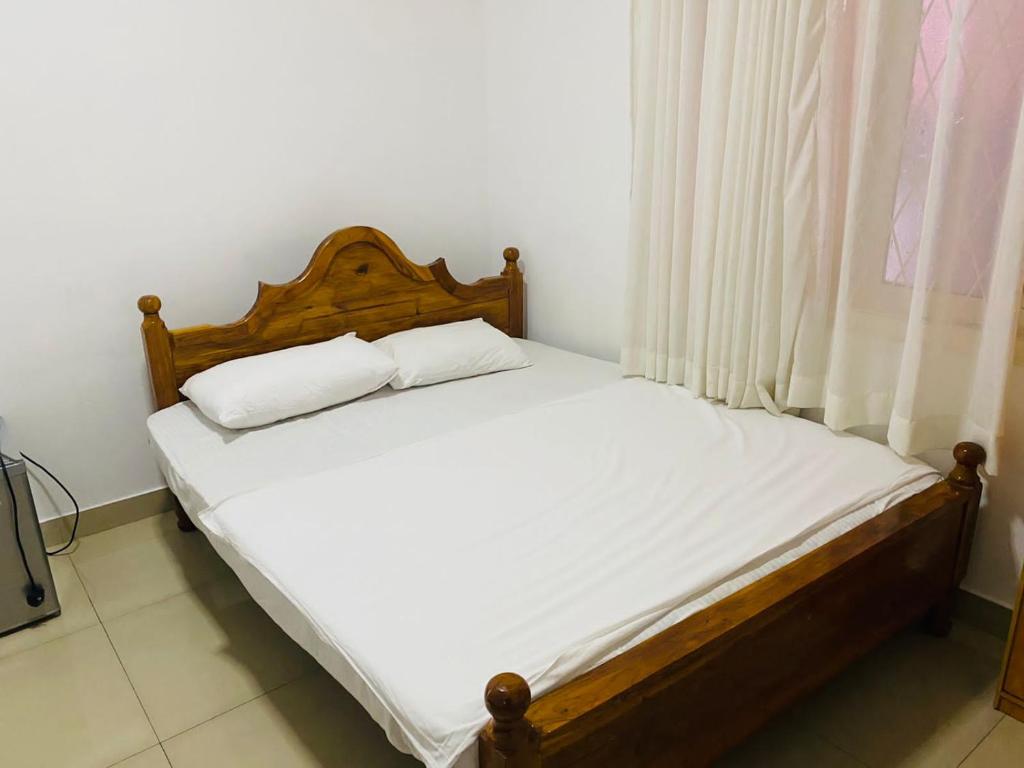 Himo Guest Inn في دهيفالا: سرير عليه وسادتين في غرفة