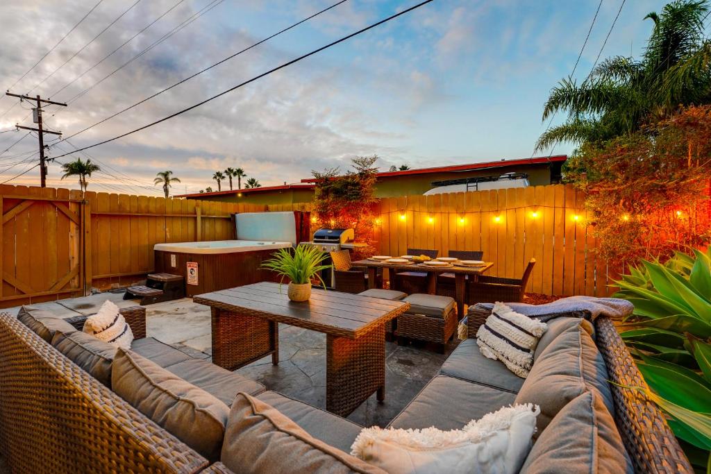 un patio con sofá, mesa y valla en Pacific Paradise - Large Patio, Hot Tub, Short Walk to Beach, & Parking en San Diego