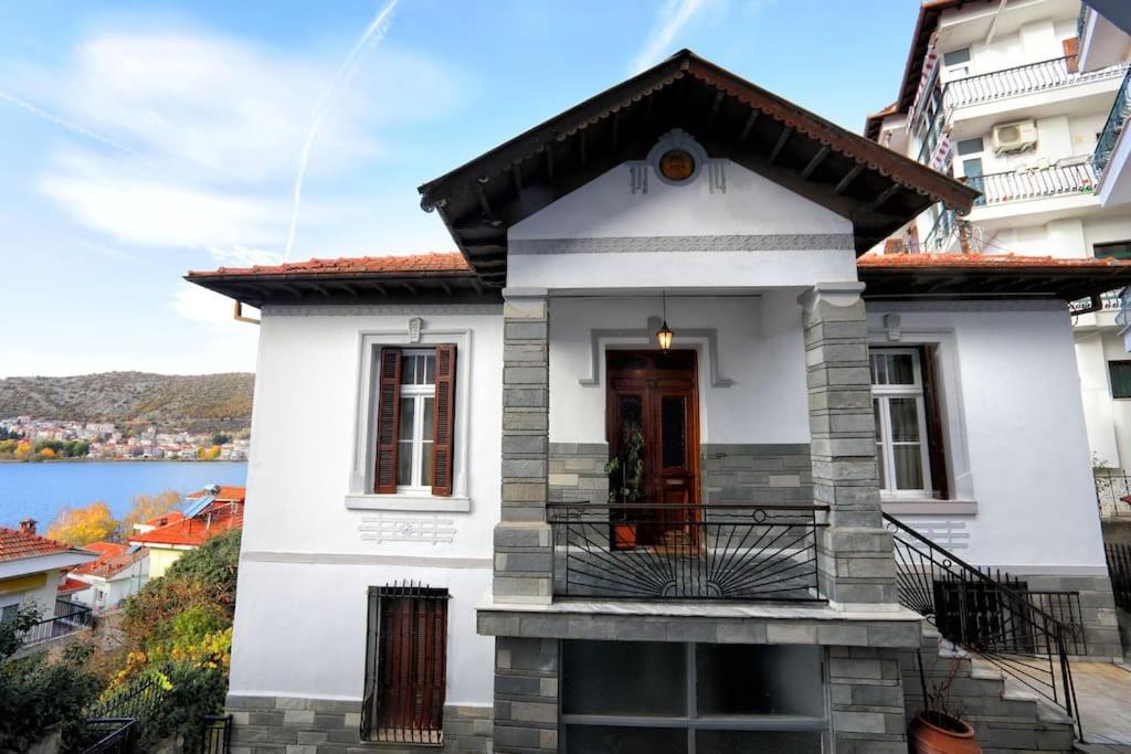 een wit huis met een balkon en een meer bij Κομψό & πολυτελές νεοκλασικό στο κέντρο της πόλης in Kastoria