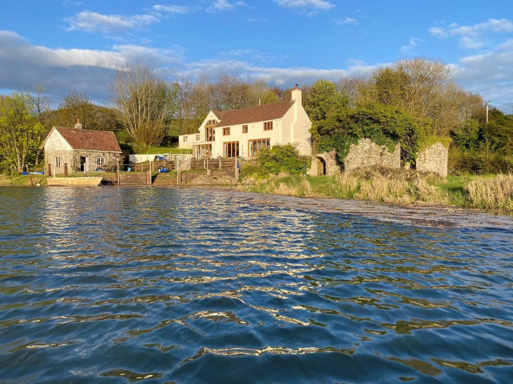 a house on the shore of a body of water at Lower Netherdowns in Littleham